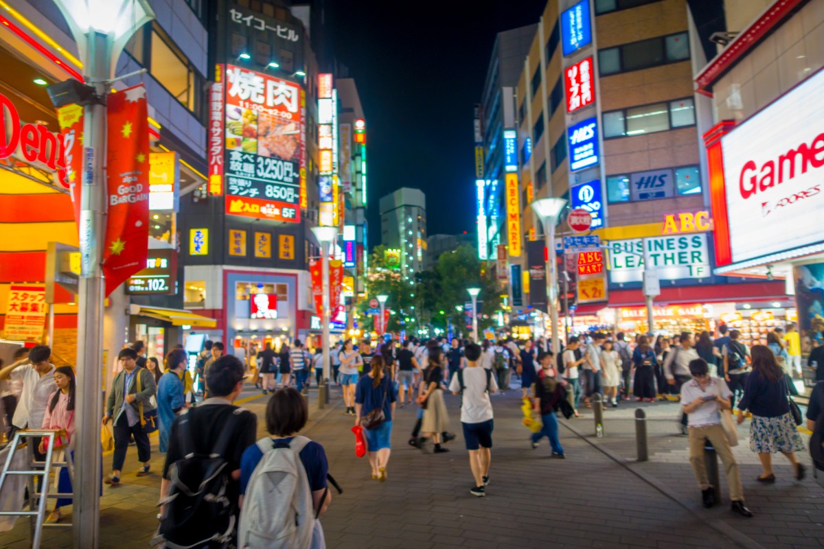 Tokyo, japan june 28 - 2017: crowd of people walking at night in the streets of ikebukuro, a commercial and entertainment district in toshima, tokyo