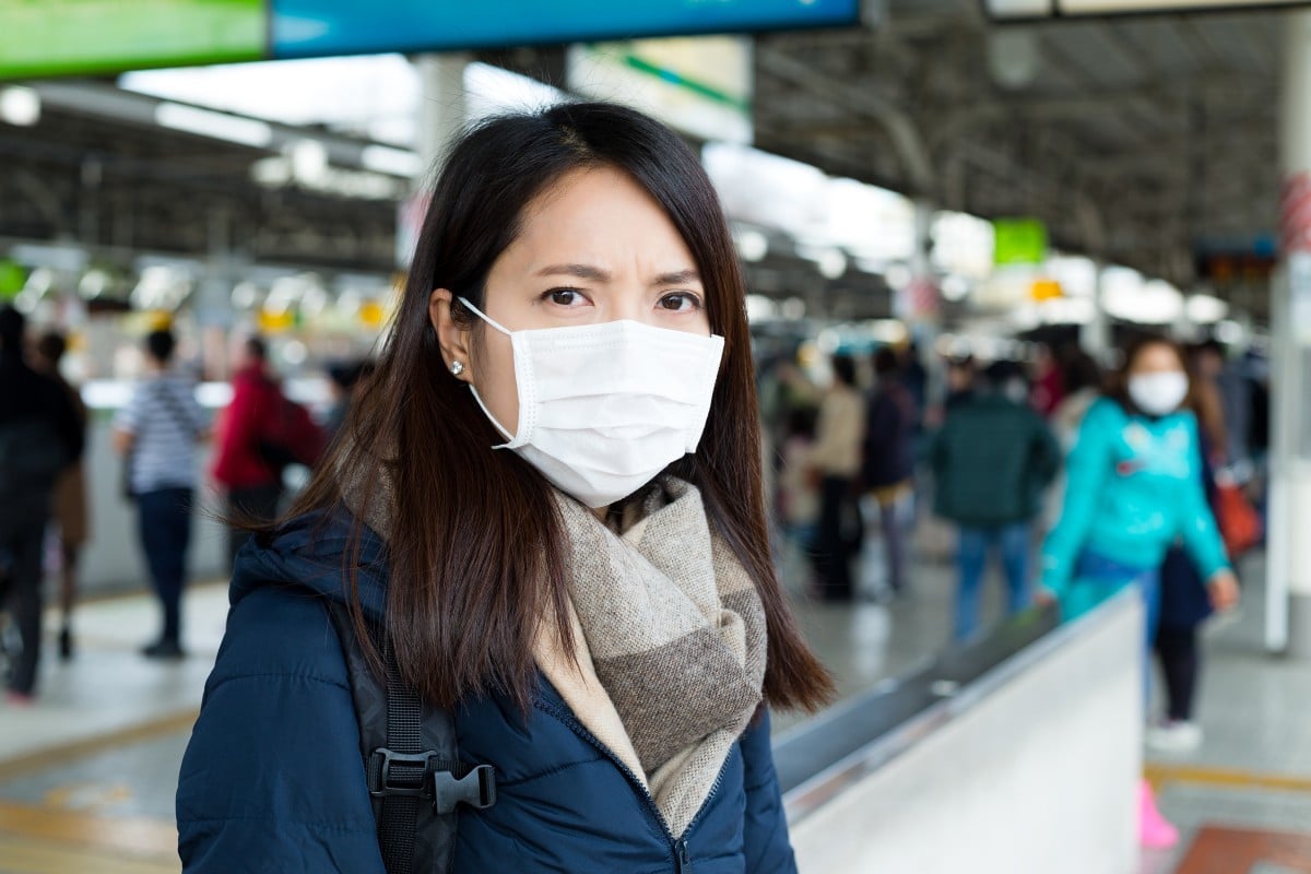 Woman wearing face mask at train station
