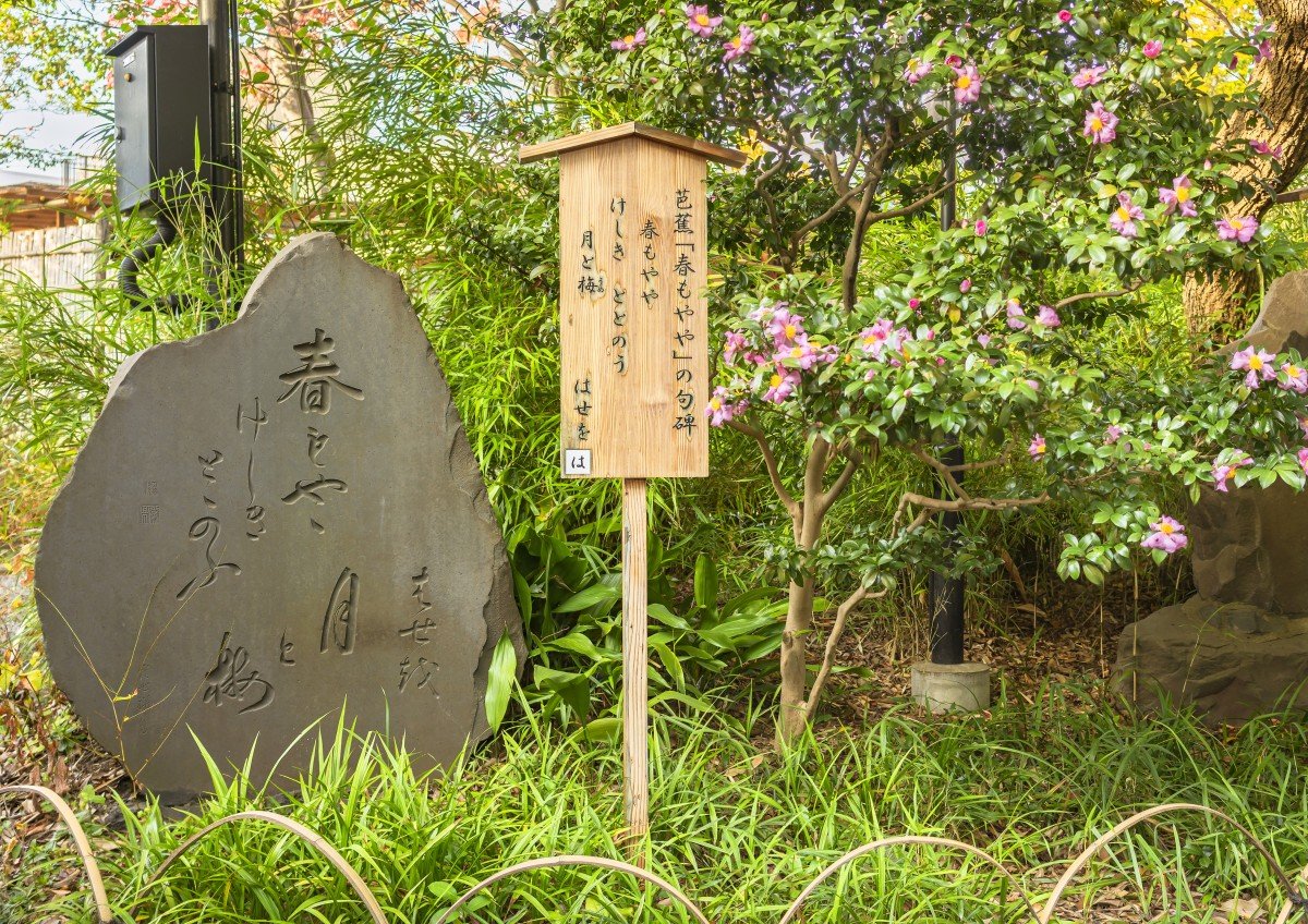 Tokio, japan - 13. november 2020: japanische kuhi-steinstele, die dem haiku-gedicht harumoyaya gewidmet ist, was den frühlingsdunst bedeutet, der vom dichter matsuo basho geschrieben wurde, der zu den mukojima-hyakkaen-gärten beigetragen hat.