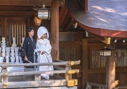 도쿄, 일본 - 2020년 10월 10일: 메이지 신궁의 황실 문장의 등불 아래 검은색 하오리 기모노와 흰색 시로무쿠를 입은 한 쌍의 일본 전통 신도 결혼식.