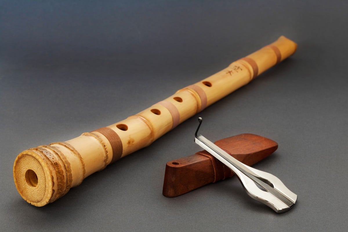 Traditional bamboo japanese flute with jew's harp on gray background