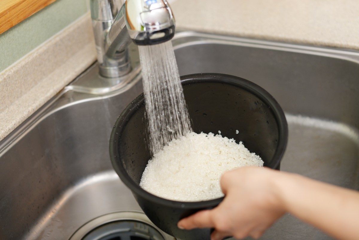 mujer manos lavando arroz