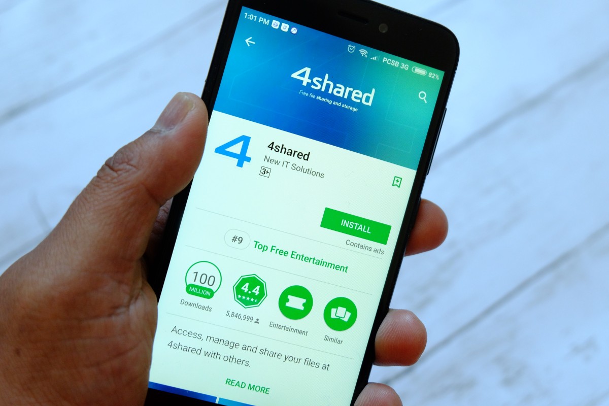 반다르 세리 베가완, 브루나이 - 2018년 7월 25일: 안드로이드 구글 플레이 스토어에서 4shared 앱이 있는 스마트폰을 들고 있는 남성 손