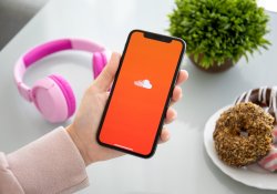 Alushta, Russia - September 28, 2018: 화면에 음악 서비스 SoundCloud가 있는 iPhone X를 들고 있는 여성. iPhone 10은 Apple Inc.에서 만들고 개발했습니다.