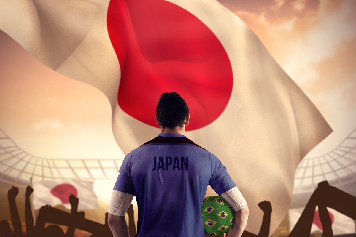 Pemain sepak bola Jepang memegang bola