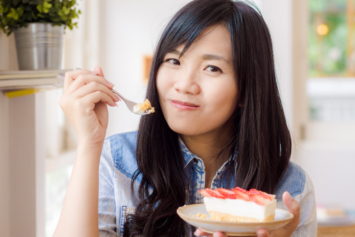 Portrait of smiling dark haired woman wearing jean shirt lap the