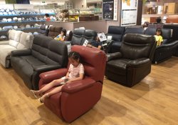 Local chinese residents sleep or rest on sofas at a store of japanese furniture and home accessory retailer nitori in wuhan city, central china's hubei province, 15 july 2018