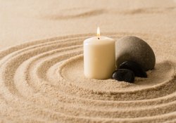 Ambiance spa bougie pierres zen dans le sable