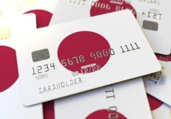 Tumpukan kartu kredit dengan bendera Jepang. Perenderan 3D konseptual sistem perbankan Jepang
