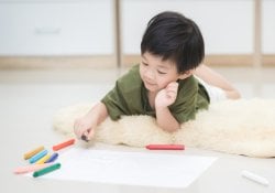 Child drawing picture with crayon