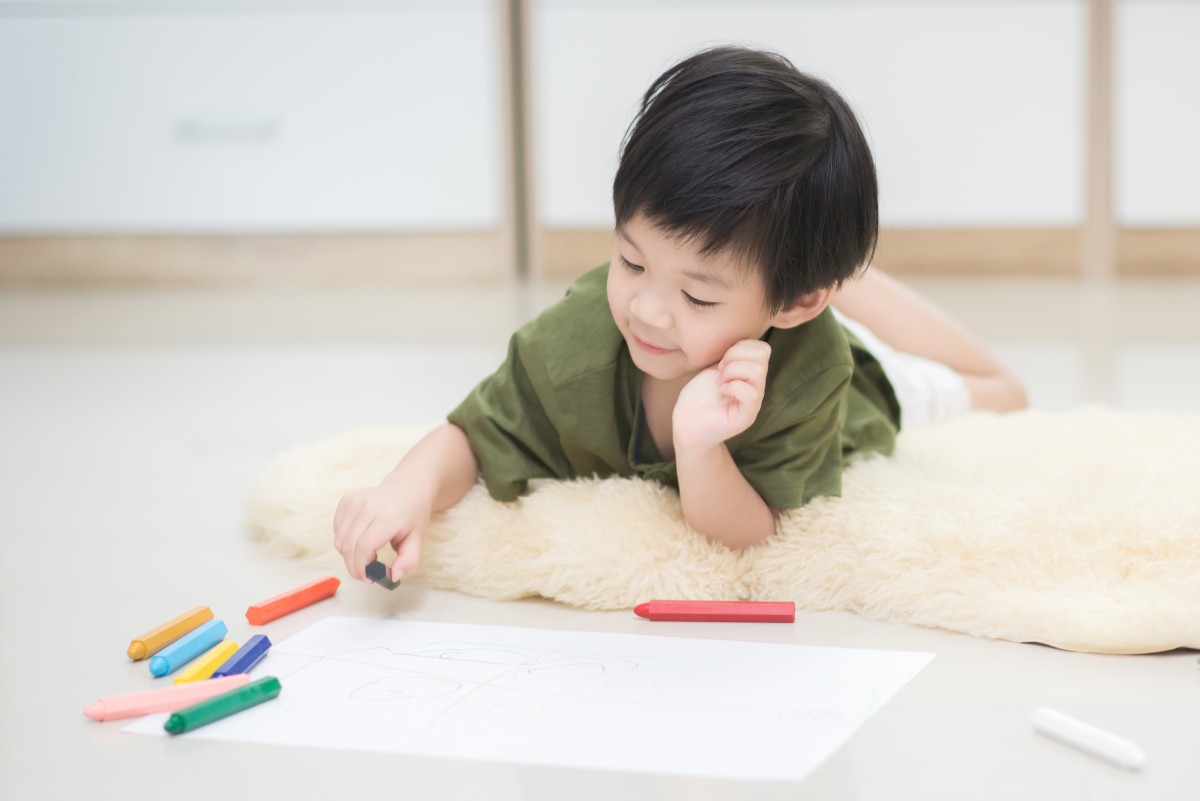 Child drawing picture with crayon