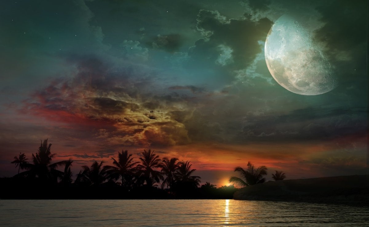 El océano, la puesta del sol y la luna.