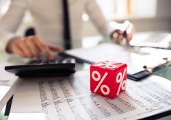 Close-up of Red Cube avec symbole de pourcentage devant l'homme d'affaires calculant la facture