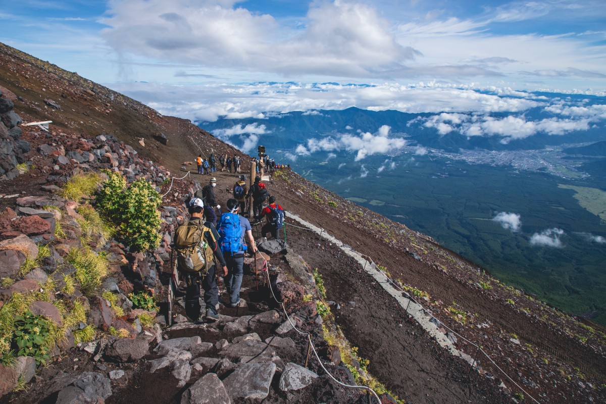 Japan -Tourists Descend from Mount Fuji Along the Yoshida Trail.