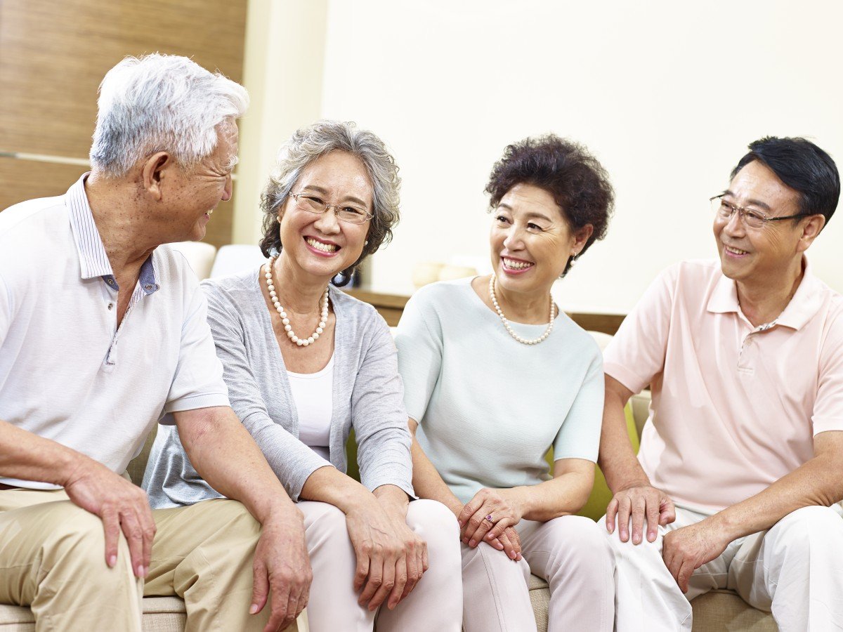 Heureux couples asiatiques âgés discutant à la maison