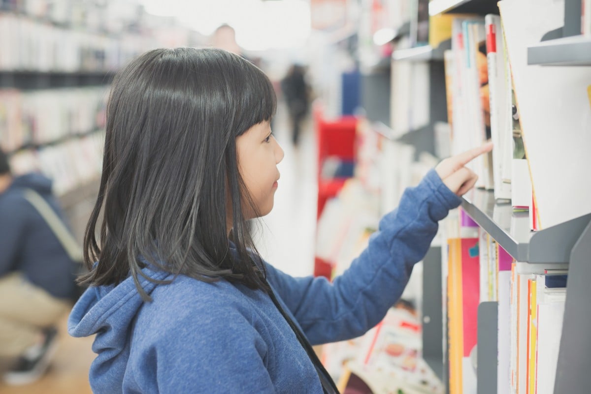 فتاة آسيوية في محل لبيع الكتب